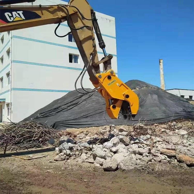 Crushing cement block with hydraulic pliers of excavator